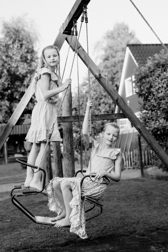 Zwart wit foto van meisjes op schommel