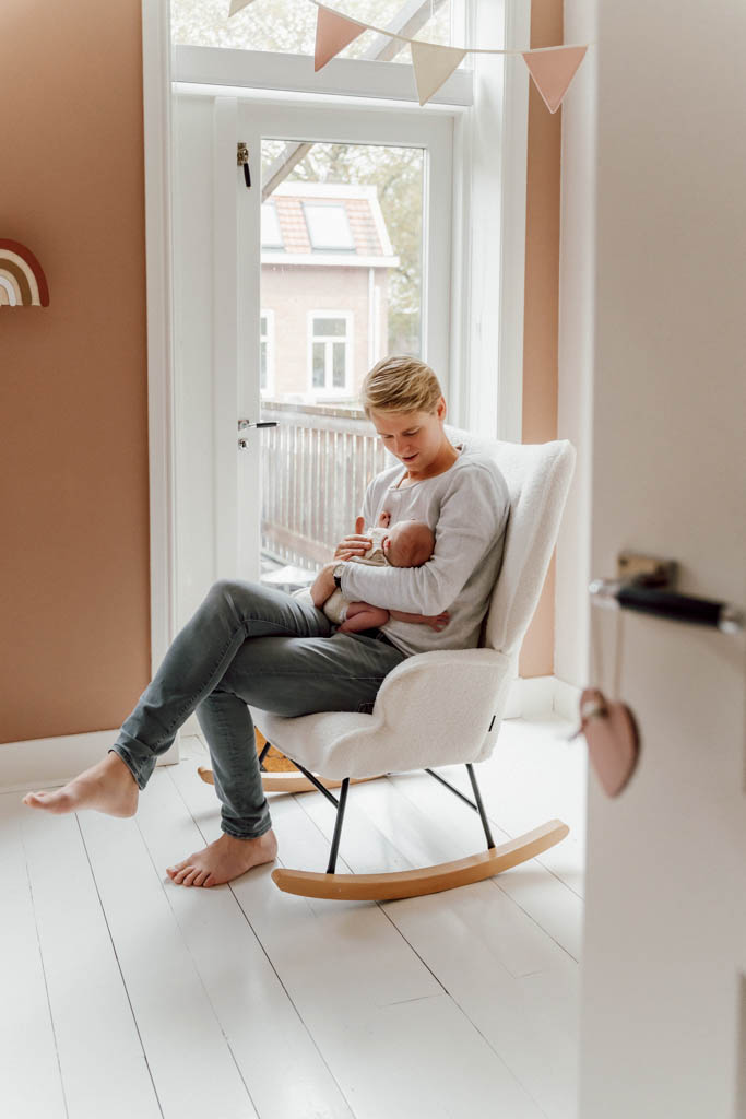 newborn fotografie fotoshoot lifestyle geposeerd shoot fotosessie baby Friesland Lemmer Sneek Heerenveen Drachten Emmeloord Joure vader met baby in schommelstoel